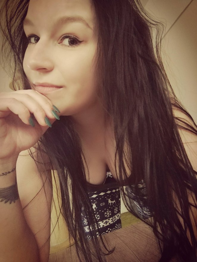 Woman in low-cut top glancing away, showing generous cleavage toward camera