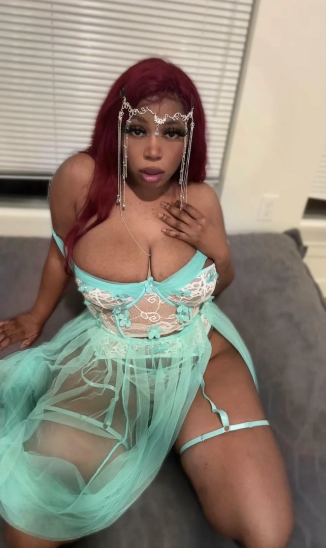 Woman proudly displaying her large bare breasts while looking at the camera