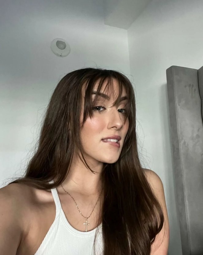 Latina woman with bangs smiling and showing off her natural charm