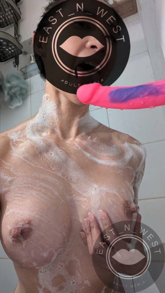 Attractive woman standing nude in a shower inviting a guest