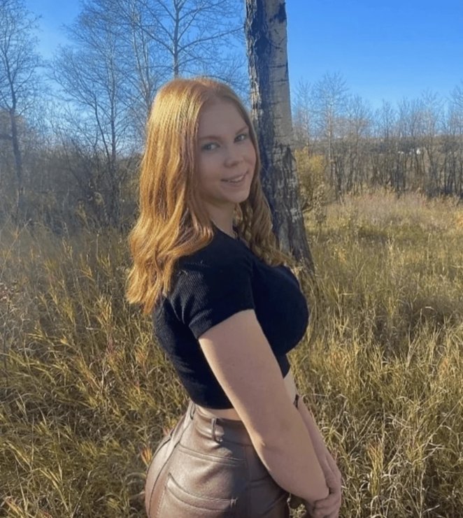 Smiling redhead woman posing outdoors in a candid natural setting