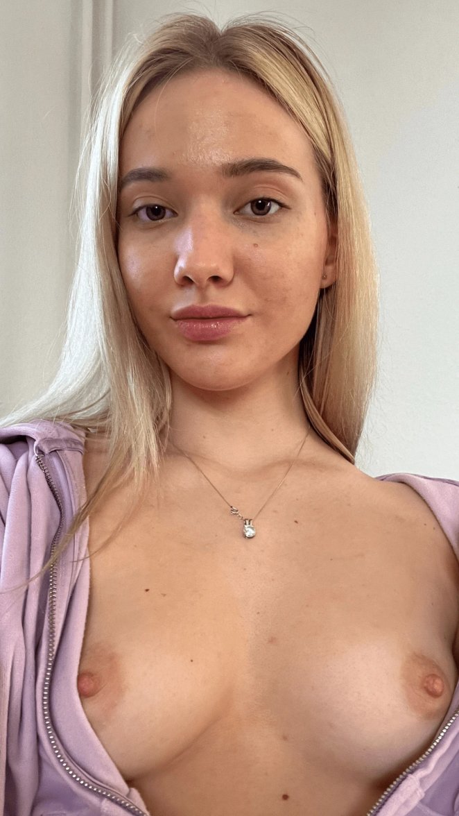 Young woman shyly covering her small breasts with her hands