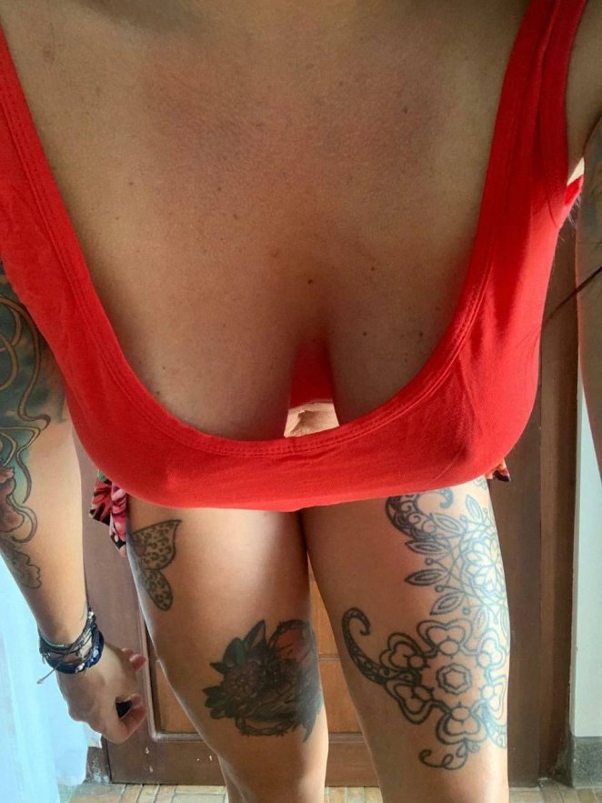 Woman with large breasts spilling out of a too-small top showing cleavage