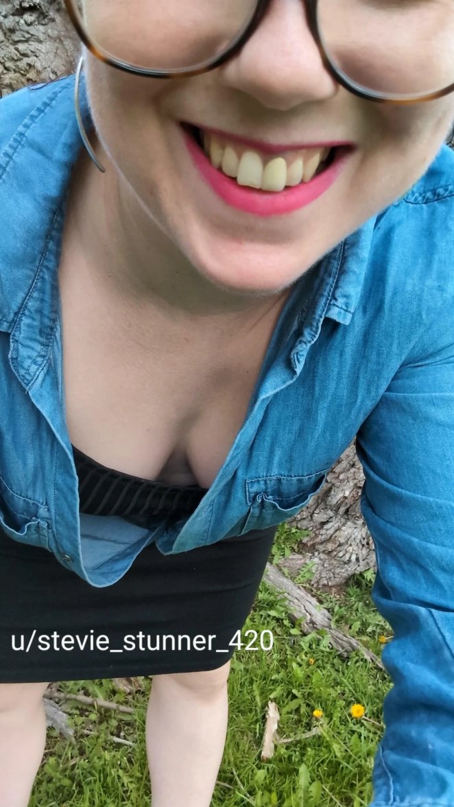 Adult woman in a floral spring outfit showing off her cleavage outdoors