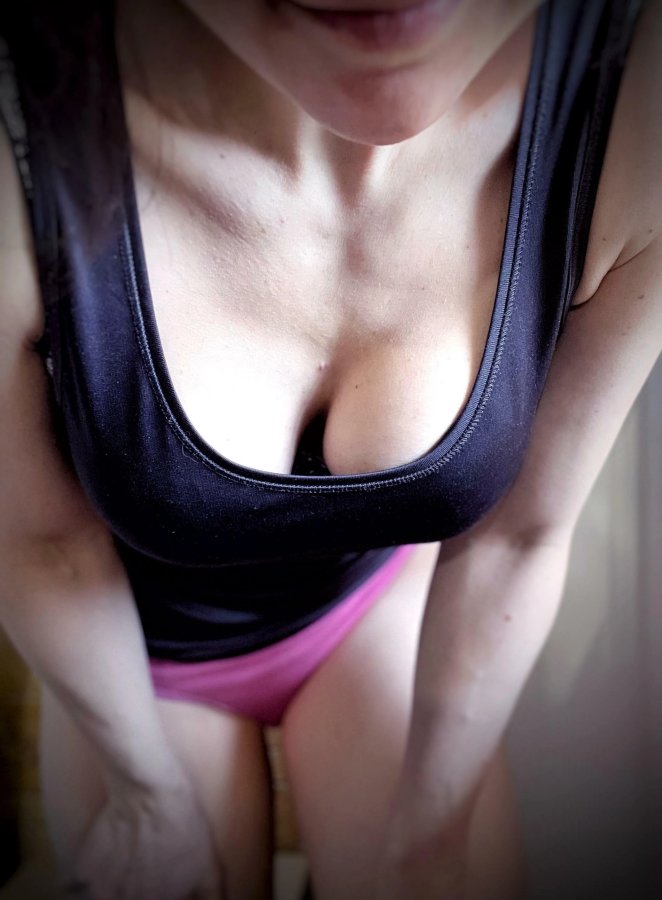 Woman in sports bra showing cleavage while getting ready to work out