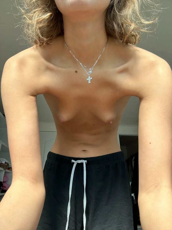 Slim young woman with a slender flat chest posing confidently