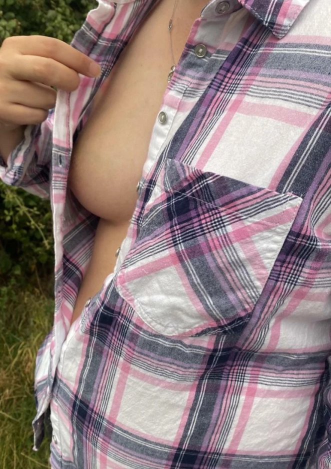 Woman showing cleavage in low cut top while outdoors at a farm