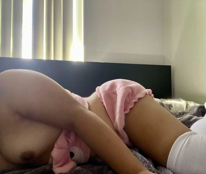 Asian woman lying face down on bed in submissive position