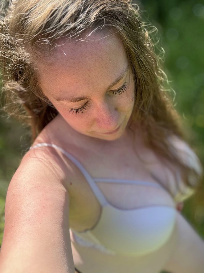 Curvy woman in playful outdoor pose inviting company on a sunny day