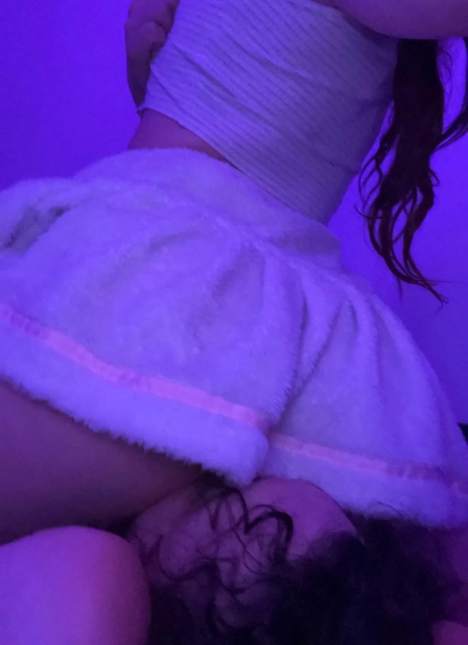 Woman sitting on partner's face while they lay beneath her