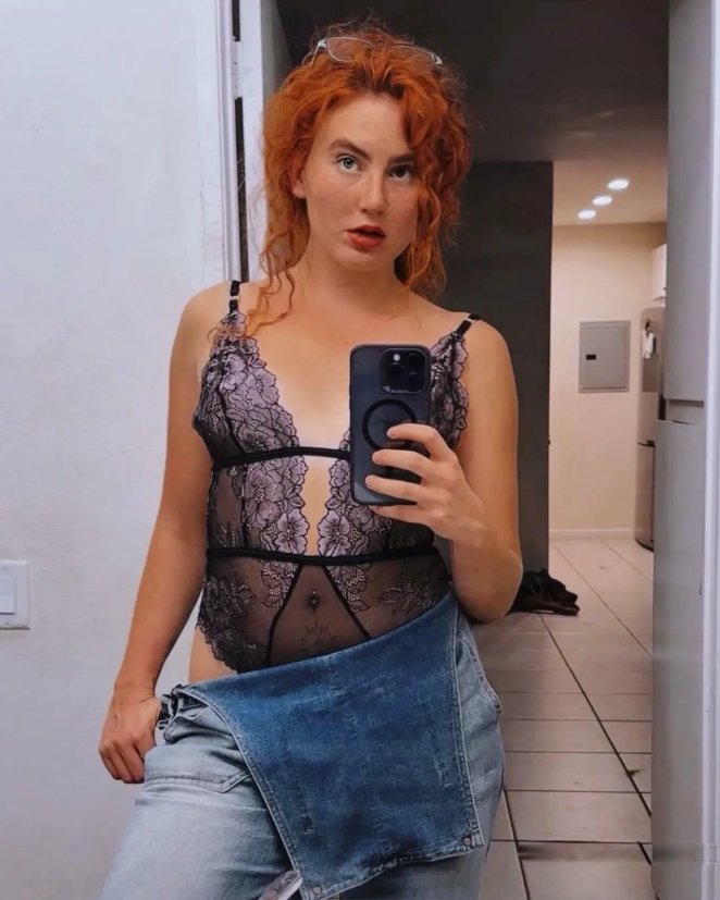 Flirtatious redhead woman posing suggestively with a playful and inviting expression