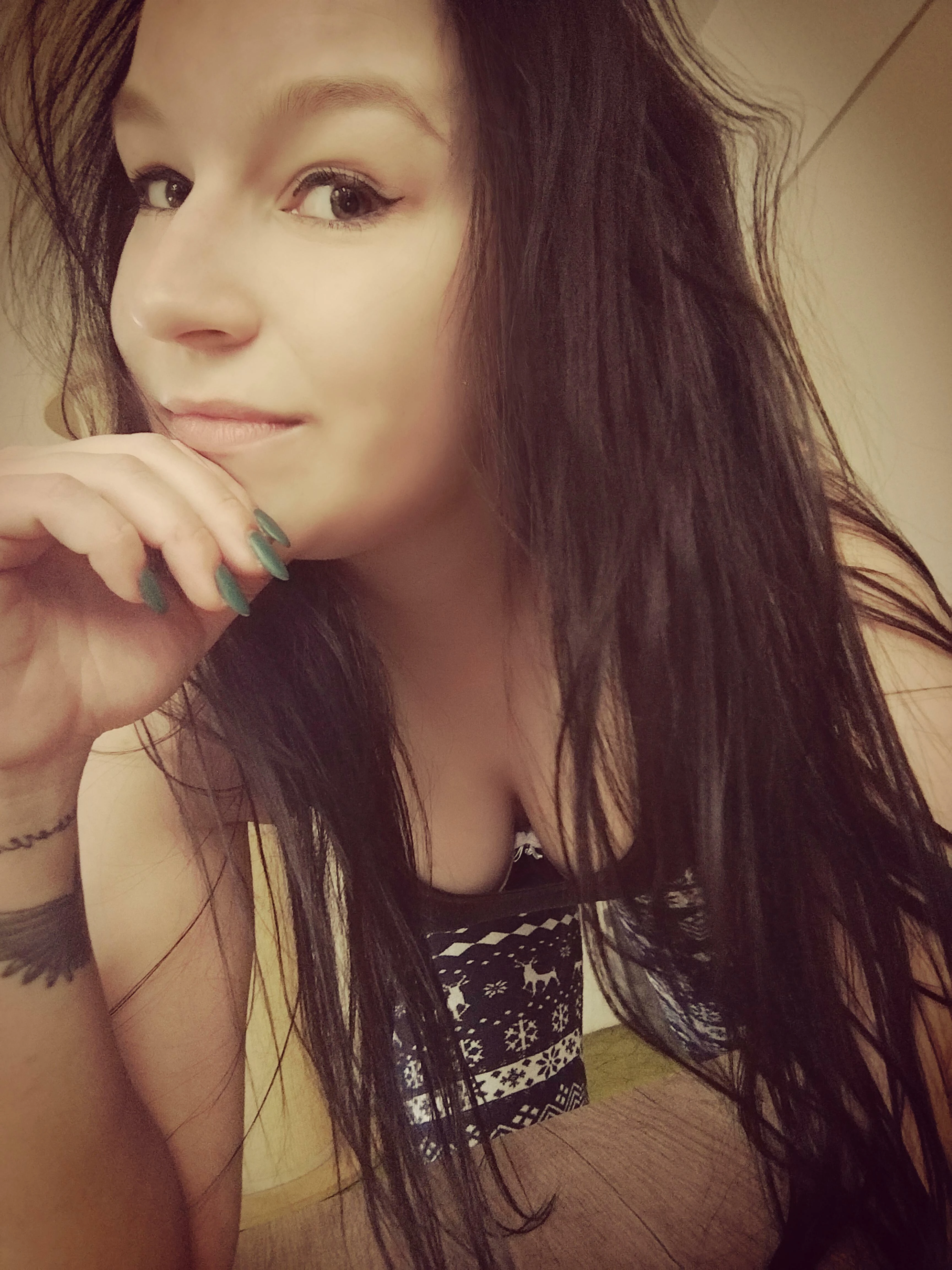 Woman in low-cut top glancing away, showing generous cleavage toward camera