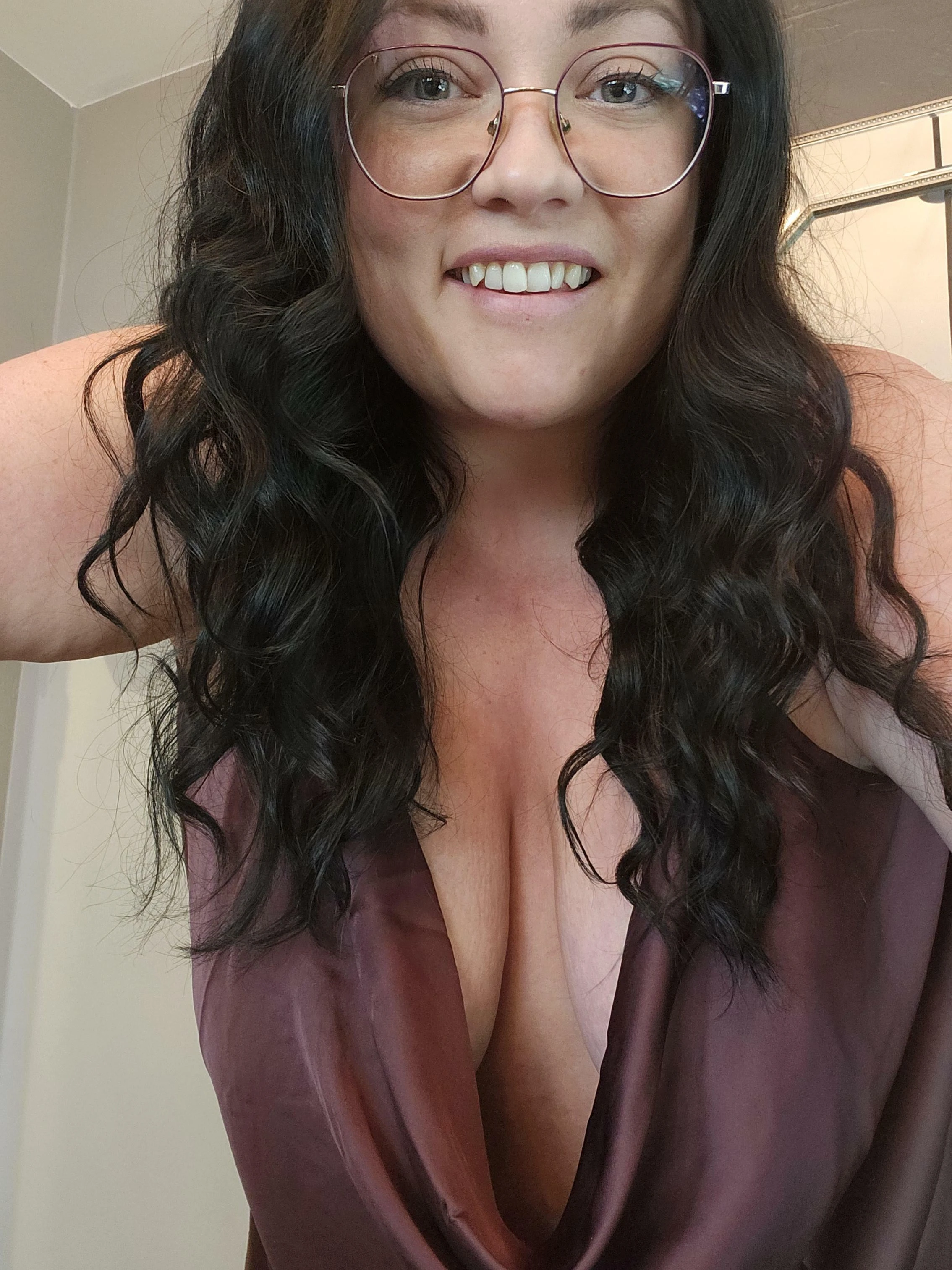 Woman confidently displaying deep cleavage while inviting viewers to look and enjoy.