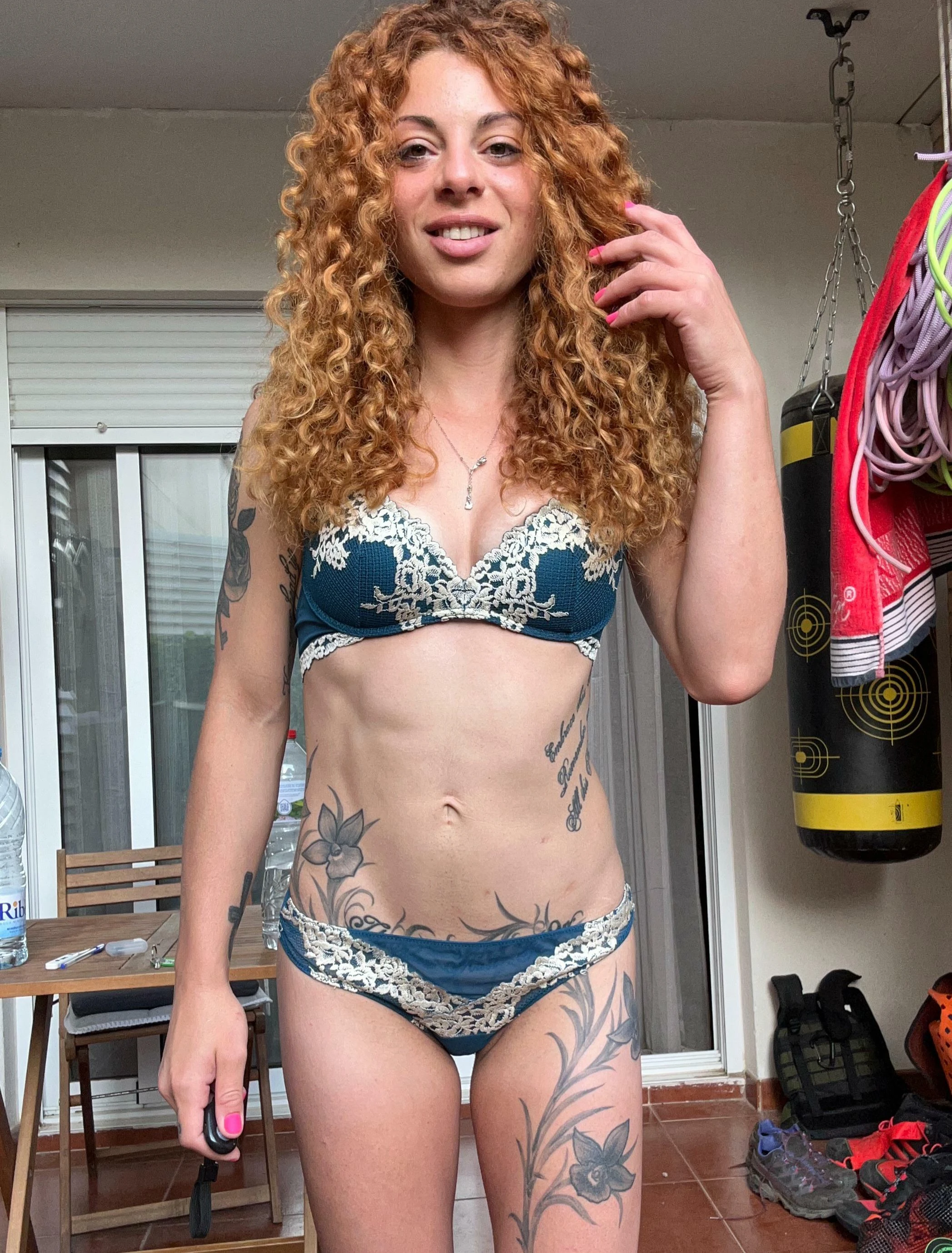 Petite redhead woman posing nude with a slender natural figure