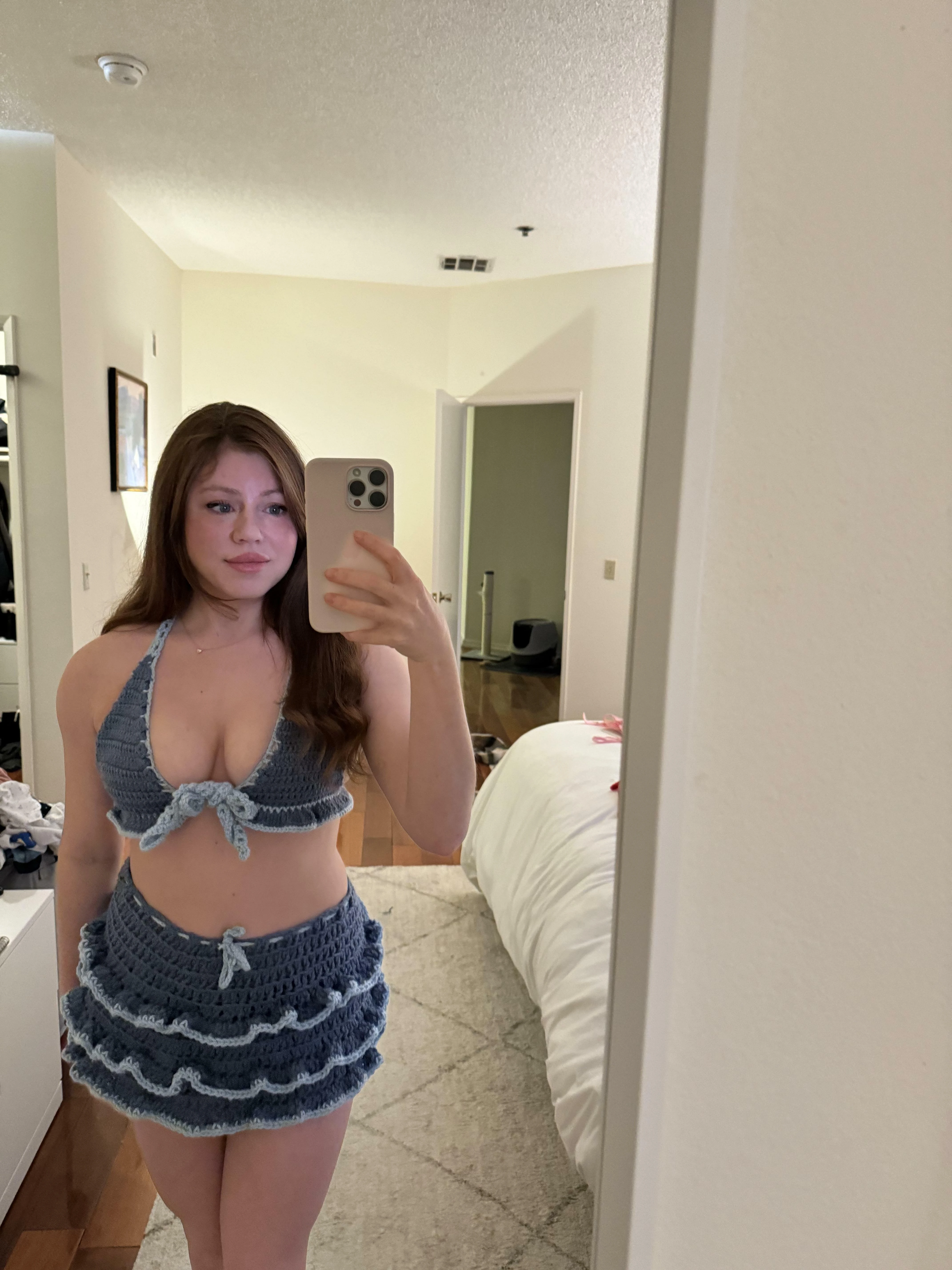 Woman showing cleavage in a handmade crochet top with open knit pattern