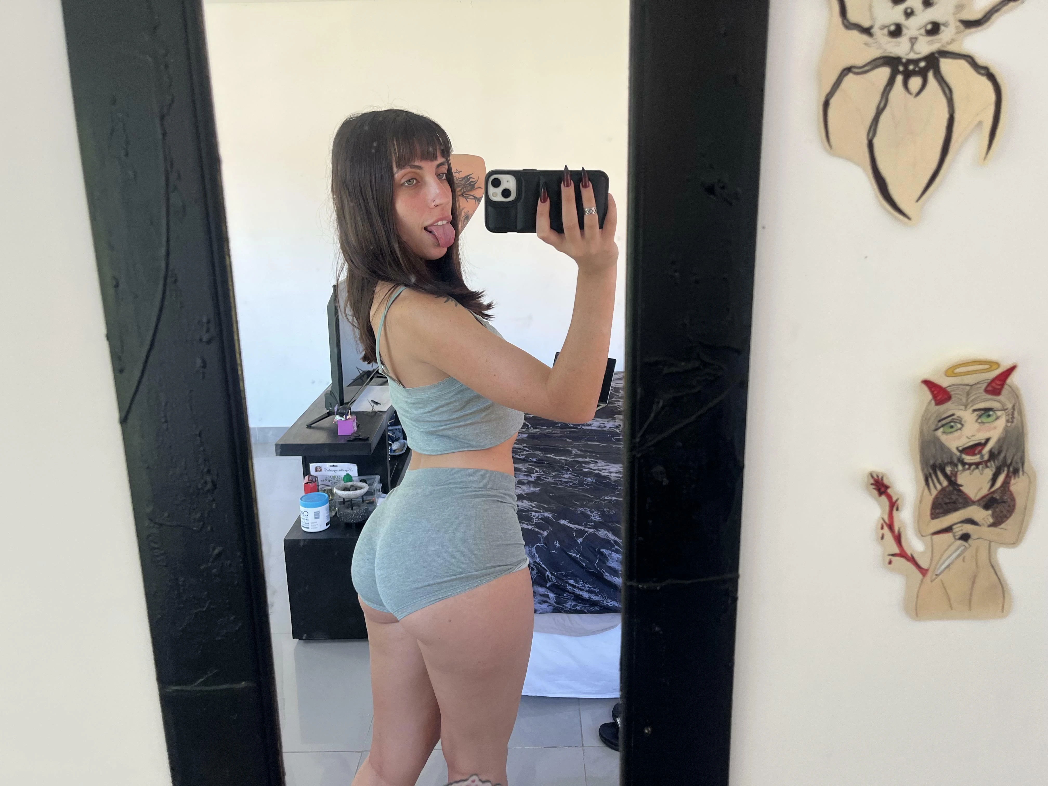 Person in yoga pants taking mirror selfie before morning workout routine