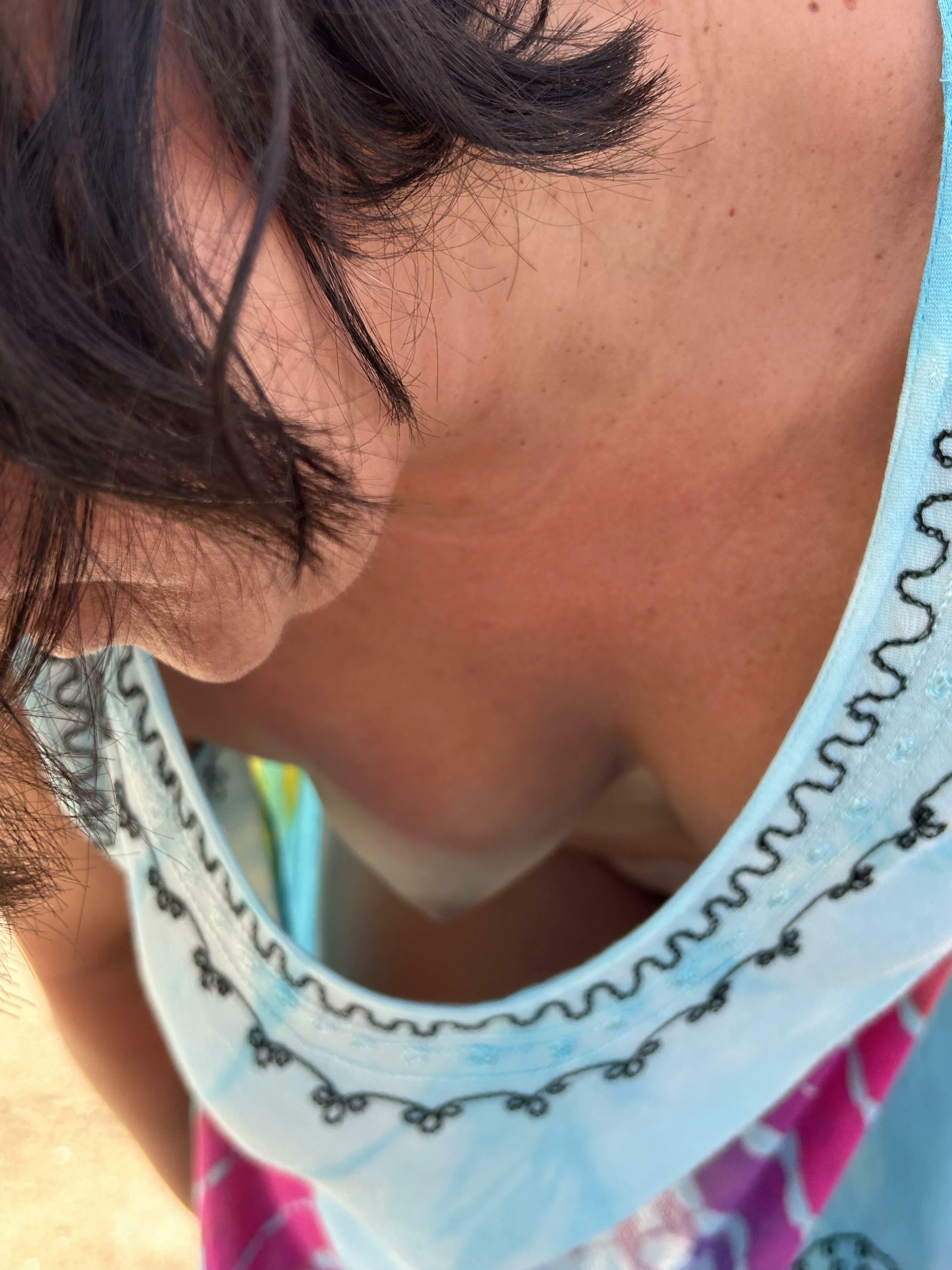 Woman in swimsuit showing cleavage while posing on a sunny beach
