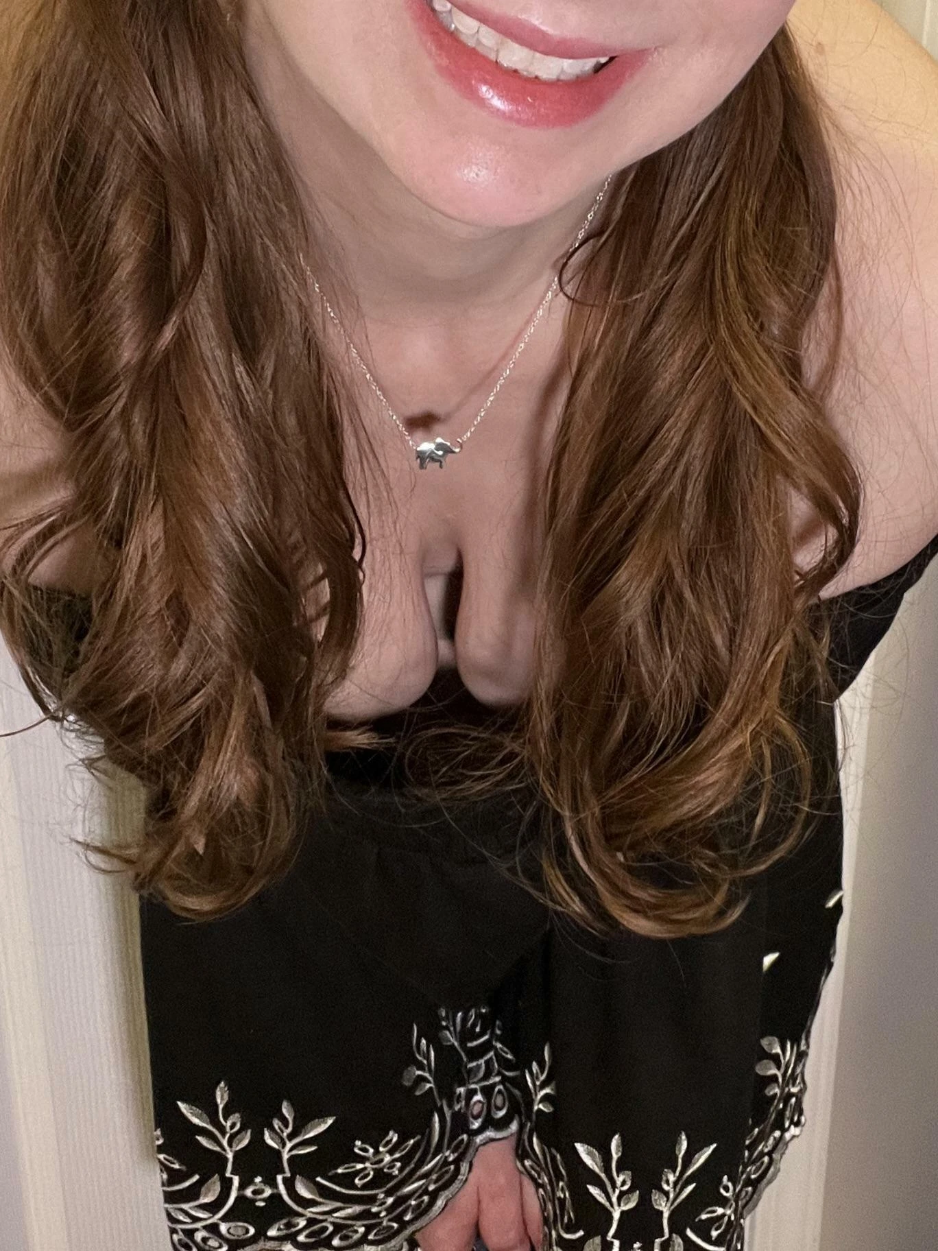 Woman bending forward showing cleavage while men look on nearby