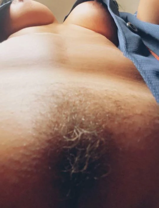 Woman in lingerie straddling another woman lying on a bed