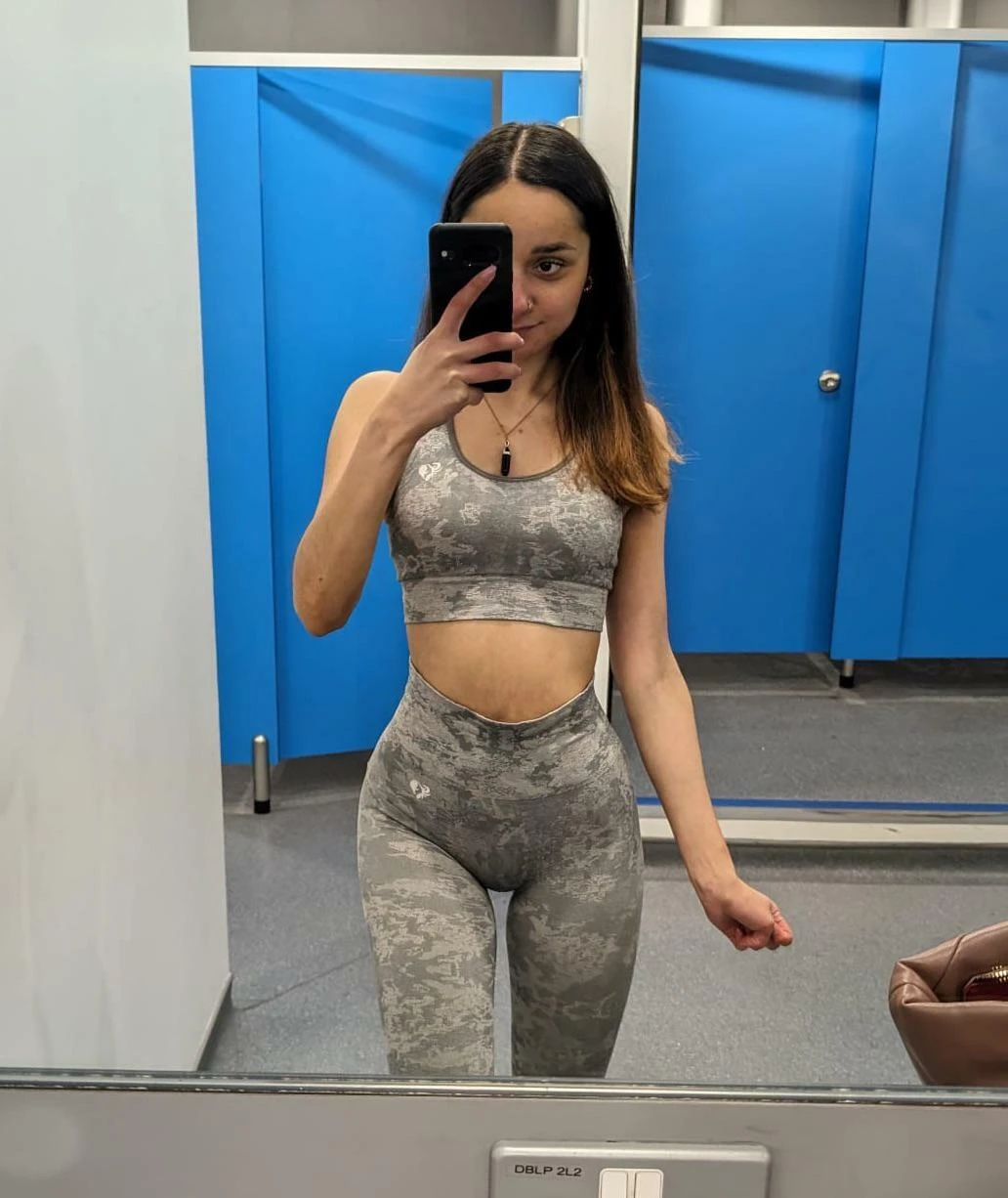 Petite nude woman posing to show off her small slender figure