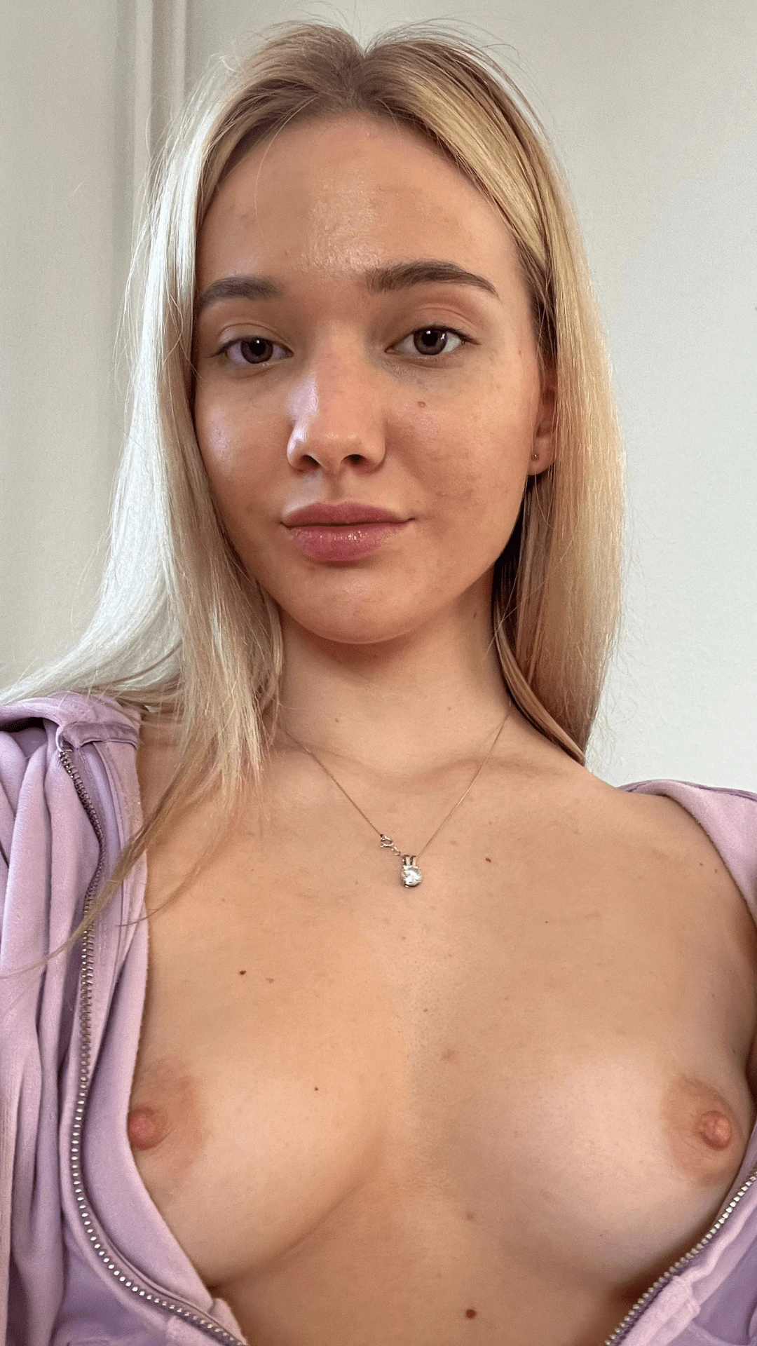 Young woman shyly covering her small breasts with her hands